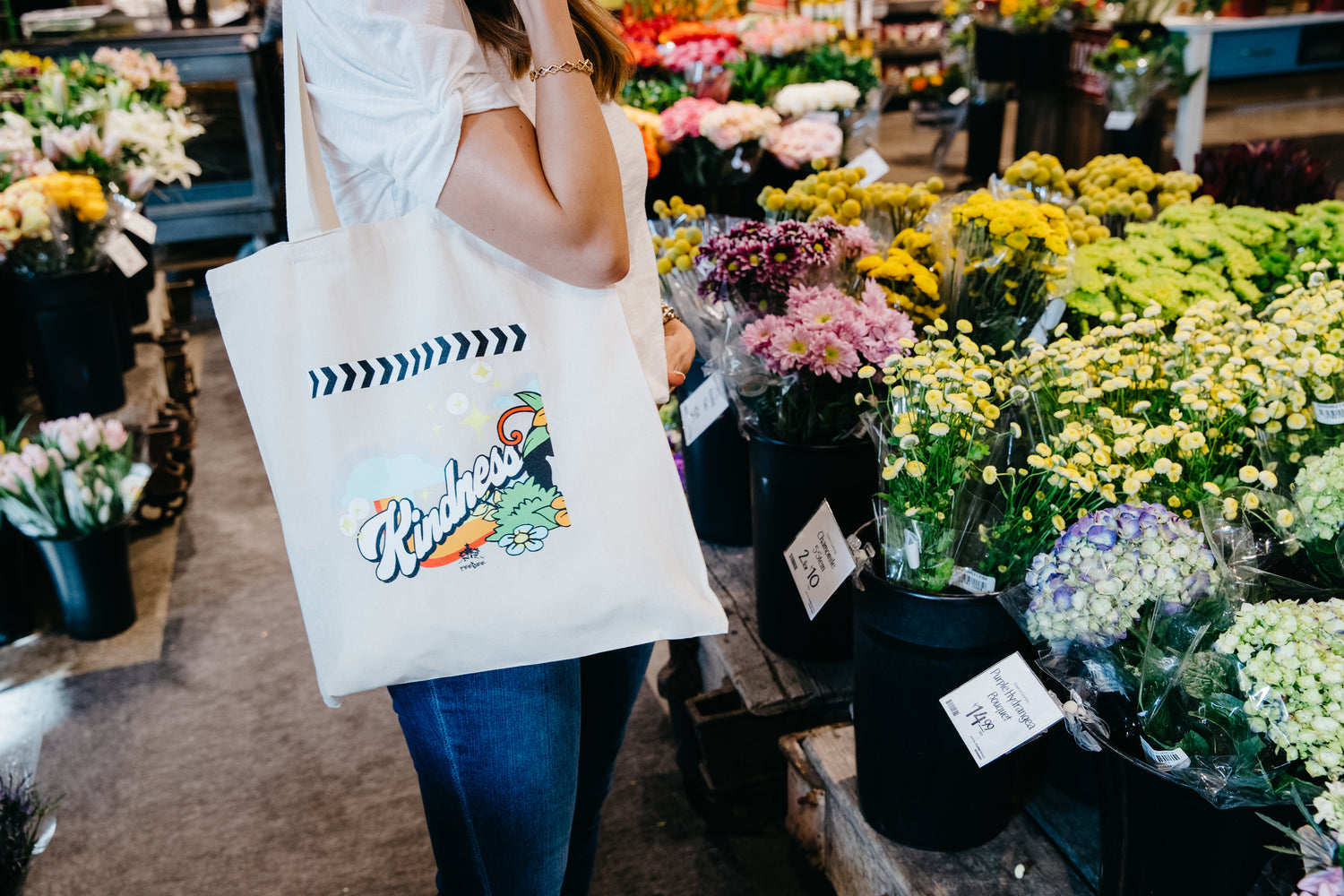 Our Kindness Tote is custom screen-printed on versatile off-white canvas, to carry your stuff with a splash of color.